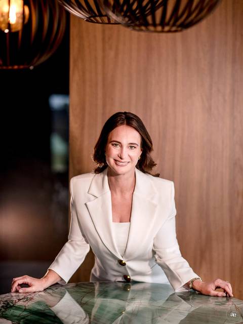 Retrato corporativo da Dra. Kátia Blume em blazer branco, com composição sofisticada e iluminação suave, valorizando sua presença profissional na odontologia estética.'