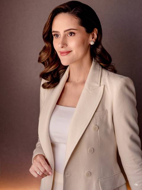Retrato corporativo da Dra. Fernanda Wisniewski em blazer claro, com composição minimalista e iluminação direcionada que valoriza a sofisticação de sua imagem profissional.'