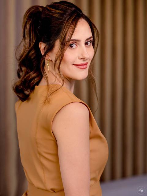 Fotografia de posicionamento da dentista Fernanda Wisniewski em perfil lateral, com traje caramelo e iluminação suave, destacando a elegância e a naturalidade de sua imagem profissional.'