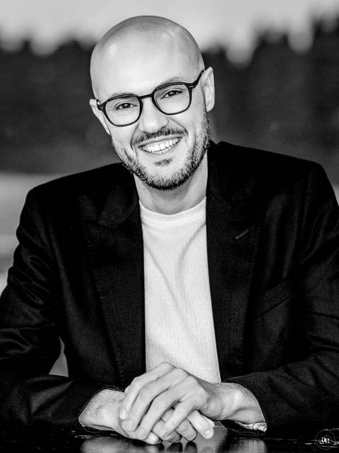 Retrato profissional masculino em preto e branco, revelando uma expressão espontânea e uma imagem de autoridade com naturalidade.'