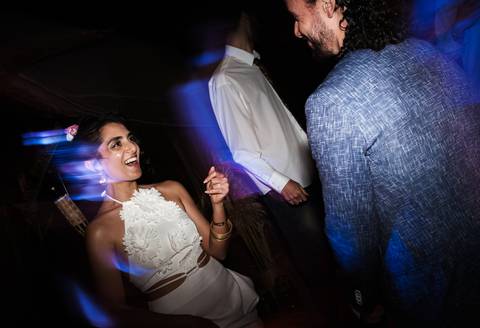 Dança dos noivos no celeiro iluminado com luzes festivas.'