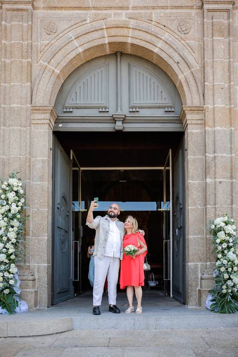 Convidados felizes a tirar foto na porta de entrada da cerimonia'
