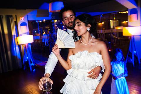 Dança dos noivos no celeiro iluminado com luzes festivas.'