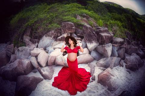 Gestante com saia rodada vermelha em cima das pedras em seu book fotográfico externo-Prainha RJ'