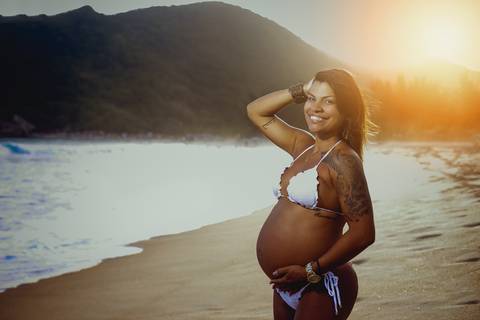 Ensaio de gestante com biquini branco ao fundo por do sol  na praia de Grumari/RJ'