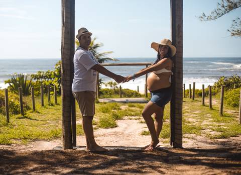 Casal de mãos dadas em ensaio de gestante/Grumari/RJ'