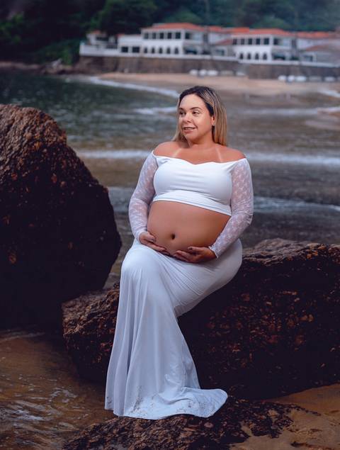 Gestante sentada em pedra em ensaio externo na urca/RJ'