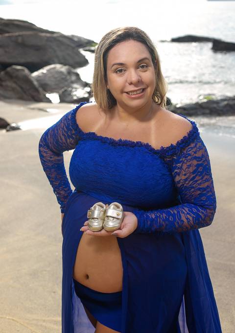 Gestante segurando sapatinhos em seu ensaio externo/Urca'