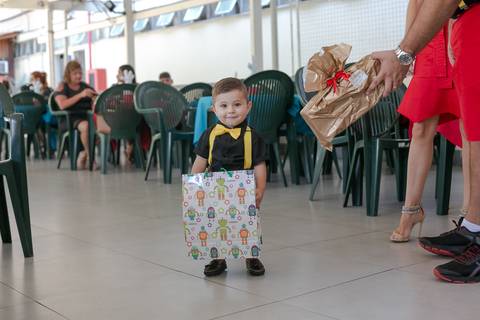Aniversariante carregando seu presente em sua festa de 1  ano em clube militar sede lagoa/RJ'