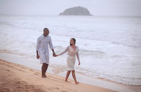 Casal caminhando na praia em ensaio pré-wedding'