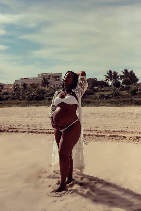 Gestante plena  segurando a barriga em seu  ensaio  na praia de Camboinhas-RJ'