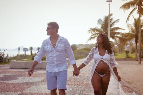 Casal caminhando em ensaio gestante na Orla de Camboinhas-Niterói'