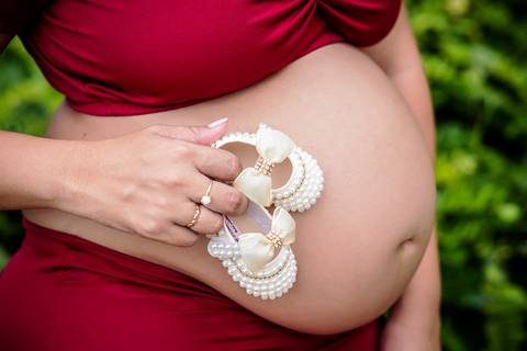 Sapatinho apoiado na barriga em ensaio externo fotográfico gestante-Grumari/RJ'