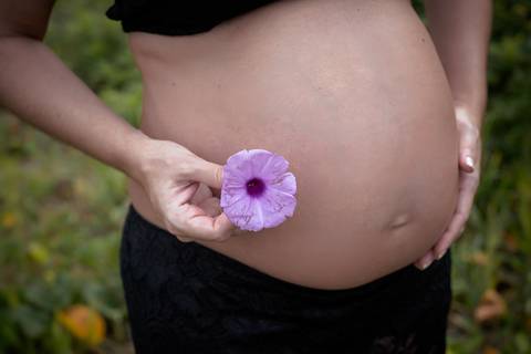 Gravida com rosa na barriga em ensaio em praia do RJ'