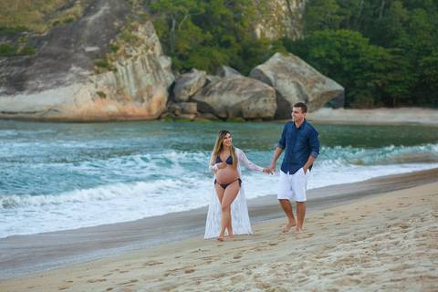 Casal caminhando na praia em ensaio de gestante RJ-Grumari'
