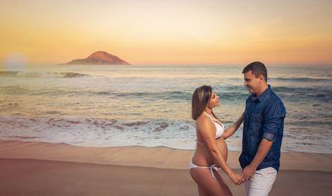 Ensaio de gestante ele segurando a mão do seu esposo em ensaio na pria-Grumari/RJ '