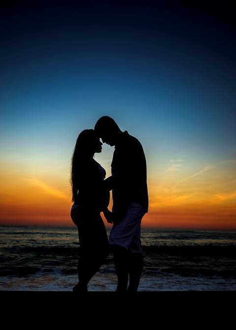 Gestante com seu esposo em seu book fotográfico ao entardecer na praia de grumari/RJ'
