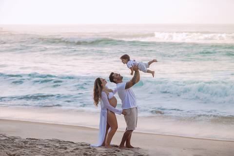 pai jogando primogênito para o alt em brincadeira em ensaio fotográfico externo de gestante em prainha-RJ'