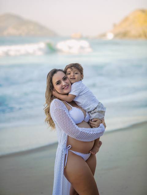 Fotografia afetiva gestante com primogênito no colo em ensaio fotográfico externo prainha/rj'