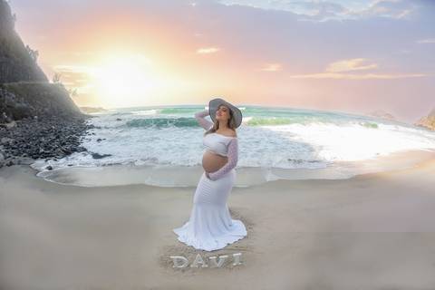 gestante posando com chapéu ao fundo mar em prainha/RJ'