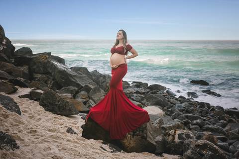 gestante em cima de pedra posando em ensaio fotográfico e'