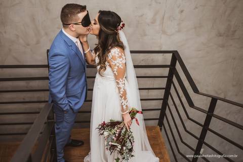 noiva rouba um beijo do noivo que esta com os olhos vendados'