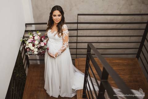 noiva vestida de noiva com buque descendo a escada para ir para o casamento'