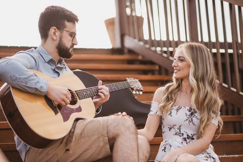 noivo tocando violao para noiva em ensaio pre casamento'