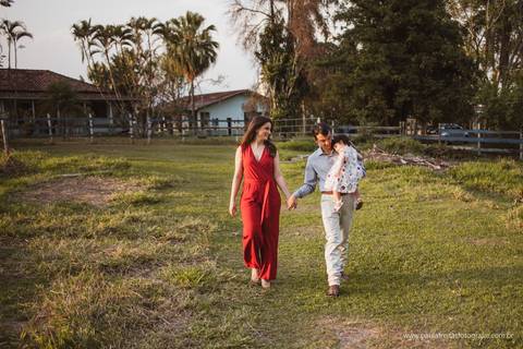 casal caminhando de mãos dadas  no campo em  ensaio fotografico'