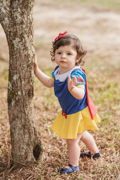criança vestida de branca de neve em ensaio fotografico'