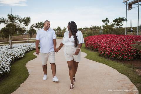 noiva e noivo caminhando em um campo florido em ensaio pre casamento fotografa paula freitas '