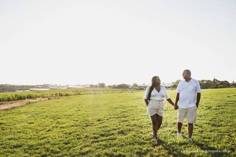 casal de mãos dadas no campo em ensaio pre casamento'