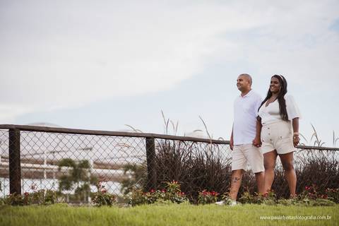 casal caminhando na grama em ensaio pre casamento'