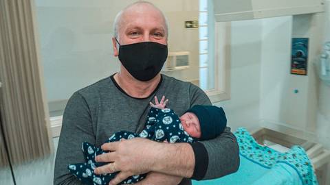 Papai louco de faceiro por segurar pela primeira vez seu filhão.'