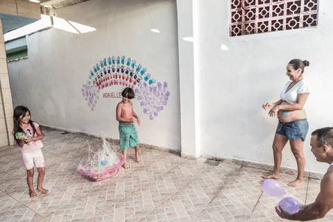 Ensaio gestante lifestyle feito com tinta e pinturas a mao filhos pai e mamae gestante em casa fotografa premiada nayara andrade fotografia de santos com fotos emocionantes do amor do lar'