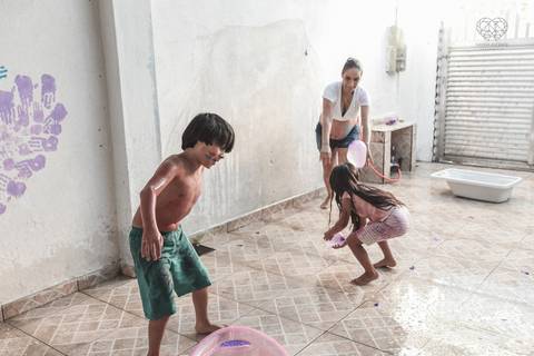 Ensaio gestante lifestyle feito com tinta e pinturas a mao filhos pai e mamae gestante em casa fotografa premiada nayara andrade fotografia de santos com fotos emocionantes do amor do lar'