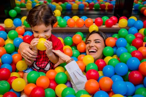 mae e filho mergulhados na piscina de bolinha na festa de aniversário infantil, fotografia realizada em vitória es'