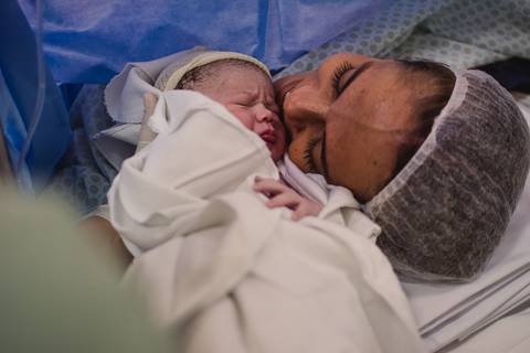 Fotografia documental de parto. Bebê encostando rostinho na mãe.'