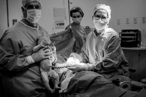 Documental de Parto. Momento em que equipe médica mostra o recém-nascido para o pai.'