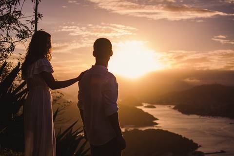 Casal contemplando o por do sol no morro do moreno em vila velha'
