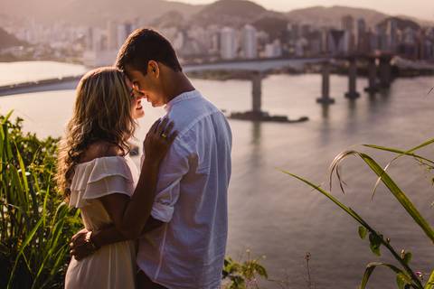 casal abraçado, com plano de fundo a terceira ponte que liga vitória e vila velha no espírito santo'