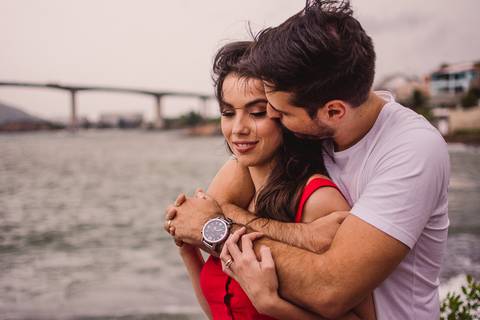 Casal abraçado. Parceiro beijando no rosto da parceira. Fotografia de ensaio de casal realizado na Ilha do Boi em Vitória, Espírito Santo.'