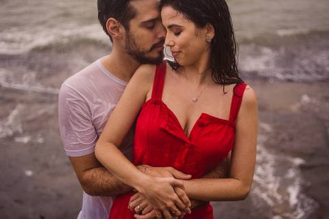 Fotografia na chuva. Ensaio fotográfico de casal. Abraçados e com rostos colados um ao outro. Ensaio realizado na Ilha do Boi, Vitória Es.'