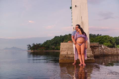 Farol da Ilha de Paquetá. Rio de Janeiro. Ensaio de Gestante. Casal sobre o deck de pedra no farol.'