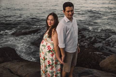 Casal de mãos dadas no por do sol na pedra da Pousada do Farol'