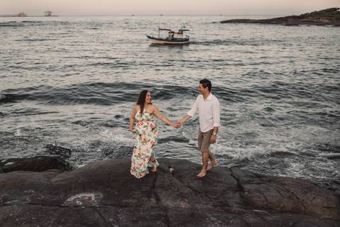Casal caminhando sobre as pedras da Pousada do Farol, Morro do Moreno, Vila Velha Es.'