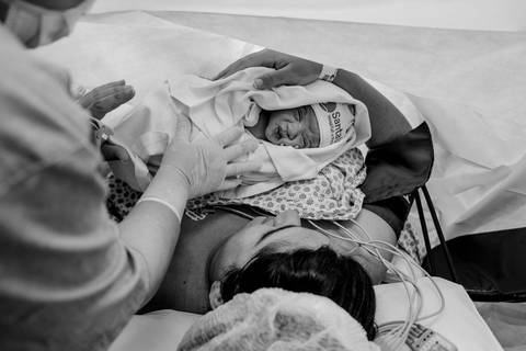 Primeiro toque da mãe no bebê recém nascido.'