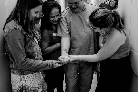 Pai mostrando a tatuagem feita no braço com pezinho do bebê.'