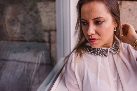 Fotografia do ensaio pessoal externo, realizado na Ilha do Frade. Modelo olhando reflexo no vidro.'