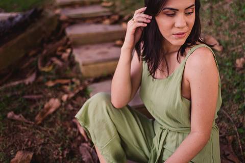 Fotografia feminina. Ensaio fotográfico. Modelo vestindo um macacão verde, de alcinha. Sentada na escadaria. Praia da Ilha do Frade. Vitória-ES.'